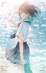 1girl :d beach blurry blurry_background bow bowtie brand_name_imitation brown_hair camera camera_around_neck collared_shirt commentary_request cowboy_shot earrings floating_hair from_side green_eyes grey_skirt highres holding holding_shoes holding_unworn_clothes jewelry light_blush looking_at_viewer ocean open_mouth original plaid_clothes plaid_skirt pleated_skirt red_bow red_bowtie school_uniform shirt shirt_tucked_in shoes short_hair short_sleeves single-lens_reflex_camera skirt smile solo stud_earrings tucking_hair unworn_shoes viewfinder white_shirt wind yukimaru_nun