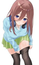 1girl absurdres blue_cardigan blue_eyes blush breasts brown_hair brown_pantyhose cardigan commentary dressing feet_out_of_frame go-toubun_no_hanayome green_skirt hair_between_eyes headphones headphones_around_neck highres large_breasts leaning_forward long_hair long_hair_between_eyes long_sleeves looking_at_viewer miniskirt nakano_miku nigi_(ngmnoym) pantyhose pleated_skirt shirt simple_background skirt solo straight_hair white_background white_shirt