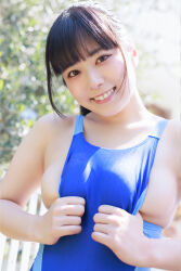 1girl black_hair blue_one-piece_swimsuit blurry blurry_background breasts gravure_idol hand_on_own_chest japanese_(nationality) large_breasts looking_at_viewer medium_hair one-piece_swimsuit outdoors photo_(medium) ponytail shinonome_umi sideboob smile solo swimsuit