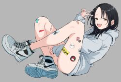 1girl :d bandaid bandaid_on_leg between_legs black_hair brown_eyes full_body grey_background grey_hoodie hand_between_legs hand_up highres hood hood_down hoodie looking_at_viewer manemane_nichinichi nagisa_akane open_mouth shoes shorts simple_background sitting smile sneakers solo sticker_on_leg tinkie v x