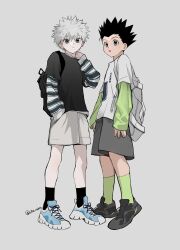 2boys alternate_costume arm_up backpack bag black_hair black_shirt black_shoes black_socks blue_eyes blue_shoes brown_eyes commentary full_body gon_freecss green_socks grey_background grey_shorts hand_in_pocket hand_on_own_shoulder highres hunter_x_hunter killua_zoldyck layered_clothes layered_sleeves long_sleeves looking_at_viewer male_focus multiple_boys open_mouth print_shirt sha_nato shirt shoes short_over_long_sleeves short_sleeves shorts simple_background sleeves_past_wrists socks striped_clothes symbol-only_commentary white_hair white_shorts