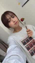 1girl aida_rikako food fork fruit highres indoors looking_at_viewer photo_(medium) real_life selfie short_hair standing strawberry voice_actor