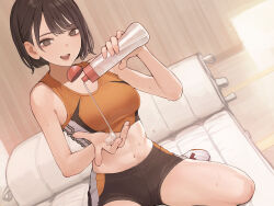 1girl absurdres black_shorts breasts brown_eyes brown_hair dutch_angle futon highres koh_(minagi_kou) looking_at_viewer lotion_bottle medium_breasts midriff mole mole_under_mouth multicolored_shorts multicolored_sports_bra open_mouth orange_sports_bra original short_hair shorts sitting solo sports_bra track_uniform wariza