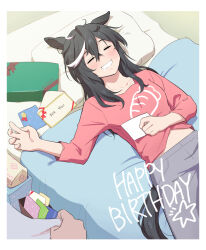 1girl =_= alternate_costume animal_ears bed blanket blush border box carrot_print commentary_request food_print gift gift_box grey_pants grin hair_between_eyes hair_down happy_birthday horse_ears horse_girl horse_tail katsuragi_ace_(umamusume) letter long_hair midriff_peek mukakin on_bed pants pillow pink_shirt shirt sidelocks sleeping smile solo solo_focus tail umamusume white_border