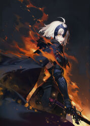 1girl ahoge armor armored_dress back backless_outfit black_cape black_dress breasts burning cape cowboy_shot dress fate/grand_order fate_(series) faulds fire fur_trim gauntlets hair_between_eyes headpiece highres holding holding_sword holding_weapon iamc95 jeanne_d&#039;arc_alter_(avenger)_(fate) jeanne_d&#039;arc_alter_(fate) looking_at_viewer looking_back medium_breasts parted_lips shade short_hair solo standing sword teeth thighs tongue torn_clothes weapon white_hair yellow_eyes