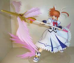 00s 1girl :d blue_eyes bow bowtie energy_wings female_focus figure fingerless_gloves full_body gloves hair_ribbon holding holding_weapon lance long_sleeves lyrical_nanoha magazine_(weapon) magic_circle magical_girl mahou_shoujo_lyrical_nanoha mahou_shoujo_lyrical_nanoha_a&#039;s octagram open_mouth orange_hair photo_(medium) polearm purple_eyes raising_heart red_bow red_hair ribbon shoes short_hair smile solo takamachi_nanoha twintails weapon winged_boots wings