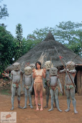 1girl 6+boys arrow_(projectile) asian barefoot black_hair bow_(weapon) breasts dark-skinned_male dark_skin day double_v full_body hut interracial jungle leaf_bikini loincloth looking_at_viewer mask multiple_boys natural_high nature navel new_guinea nipples outdoors photo_(medium) primitive short_hair sky small_breasts small_nipples standing toes topless_female tree tribal tropical v war_paint watermark weapon you_gonna_get_raped