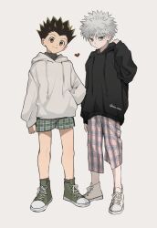2boys alternate_costume arm_up black_hair black_hoodie black_shirt blue_eyes brown_eyes closed_mouth commentary drawstring gon_freecss green_shoes grey_background grey_hair hand_in_pocket hand_on_own_shoulder hashtag-only_commentary heart highres hood hood_down hoodie hunter_x_hunter killua_zoldyck long_sleeves looking_at_viewer looking_to_the_side male_focus multiple_boys plaid_clothes sha_nato shirt shoelaces shoes short_hair shorts side-by-side sideways_glance simple_background sleeves_past_wrists smile sneakers standing white_hoodie white_shoes widow&#039;s_peak