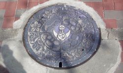 japan manhole no_humans osaka outdoors photo_(medium) sidewalk tower_of_the_sun