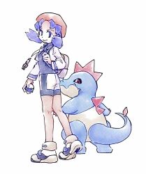 Rule 34 | 1girl, bike shorts, blue eyes, blue hair, closed mouth, croconaw, cropped jacket, gen 2 pokemon, hat, highres, holding, holding poke ball, holding strap, jacket, kneepits, kris (pokemon), long hair, nintendo, open clothes, open jacket, pink hat, poke ball, pokegear, pokemon, pokemon (creature), pokemon gsc, shirt, shoes, smile, standing, tan carbonnn, twintails, white background, white shoes