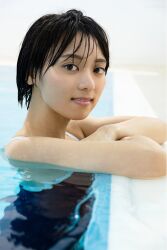 1girl black_hair crossed_arms flat_chest japanese_(nationality) looking_at_viewer monami_suzu one-piece_swimsuit partially_submerged photo_(medium) pool short_hair smile swimsuit water wet