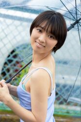 1girl black_hair blue_dress blurry blurry_background dress flat_chest from_side japanese_(nationality) looking_at_viewer monami_suzu outdoors photo_(medium) short_hair smile umbrella