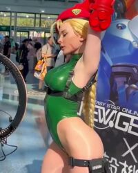 1girl animated ass bare_legs bare_shoulders blonde_hair bodypaint braid breasts cammy_white cammy_white_(cosplay) cosplay covered_navel curvy day fingerless_gloves garrison_cap gloves green_leotard hat highleg highleg_leotard jenna_lynn_meowri large_breasts leggings leotard lips long_hair looking_at_another lowres multiple_boys multiple_girls photo_(medium) real_life red_gloves shiny_skin skindentation smile sound spandex street_fighter street_fighter_v stretching thong_leotard twin_braids very_long_hair video wide_hips