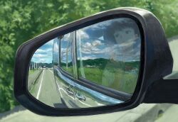 1boy black_hair blue_sky blurry blurry_background car cloud cloudy_sky commentary_request day highres looking_outside motor_vehicle multiple_reflections o_kizo open_mouth original power_lines reflection road rural scenery short_hair side-view_mirror sky solo